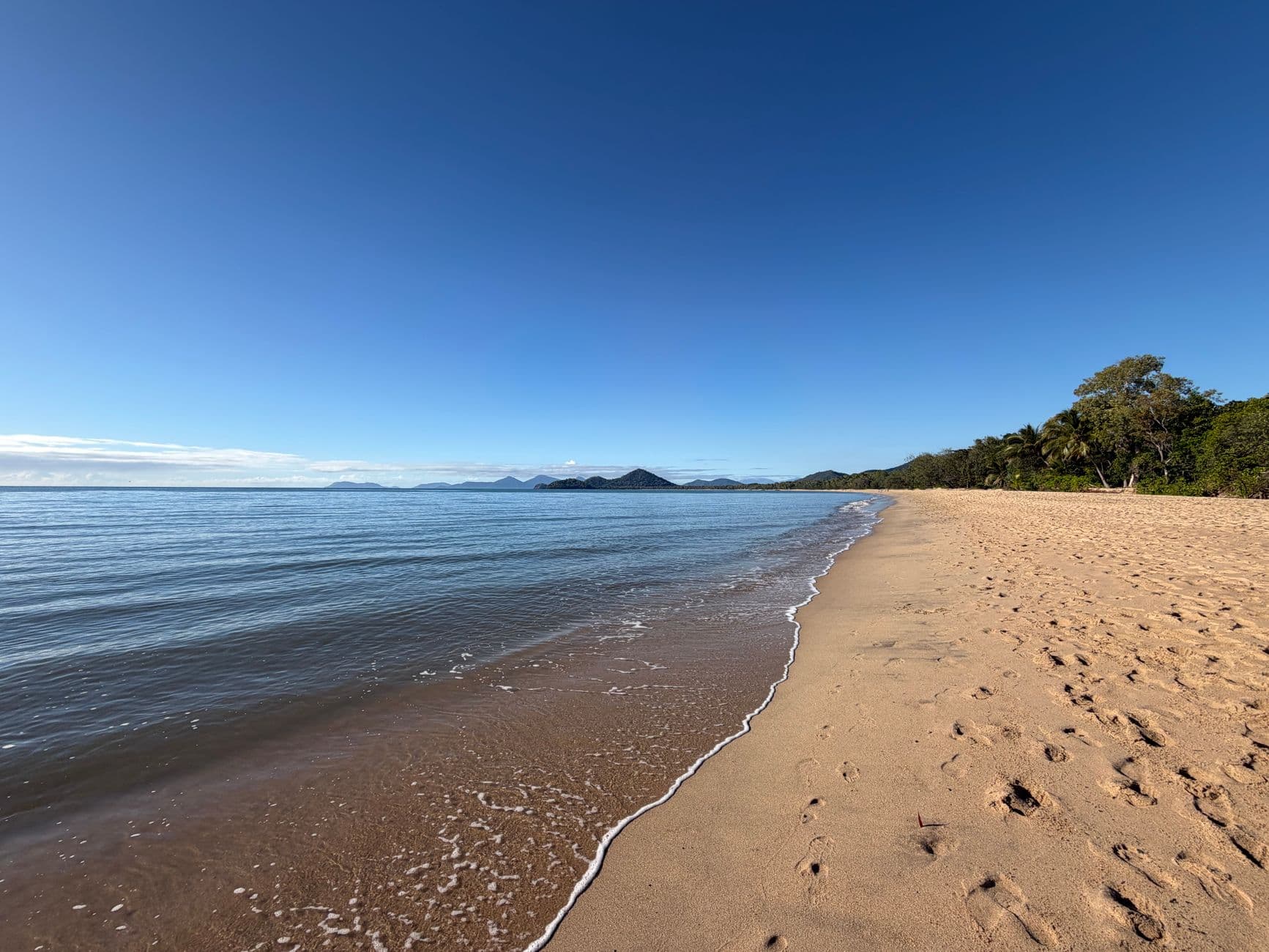 Sandy shoreline and calm water at Palm Cove north of Cairns