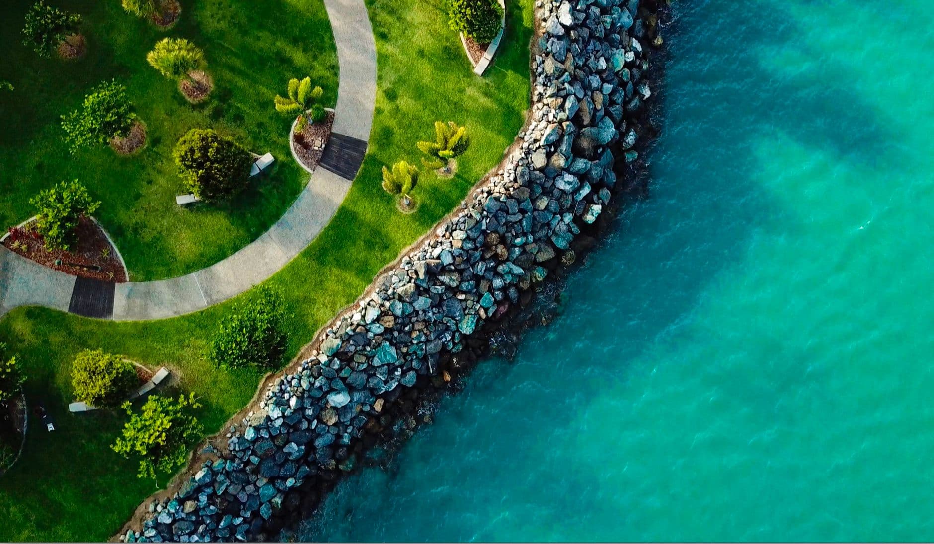 Aerial view of a landscaped waterfront beside turquoise water at Airlie Beach