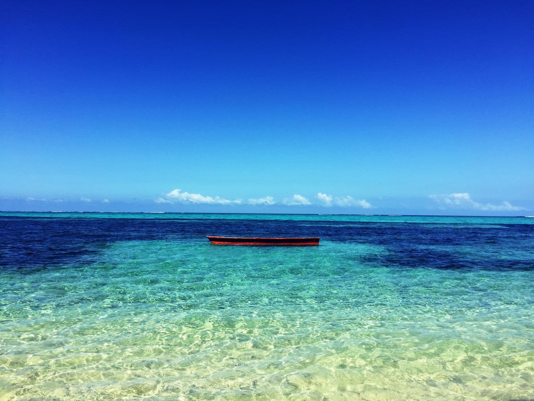 A tropical atoll and boat, representative imagery for a Fiji holiday